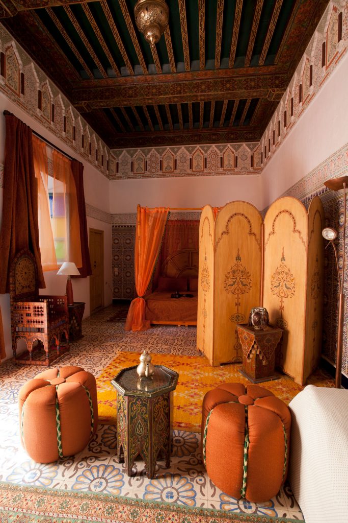 Authentic Moroccan inspired bedroom consisting of Arabic rugs and Moroccan poufs
