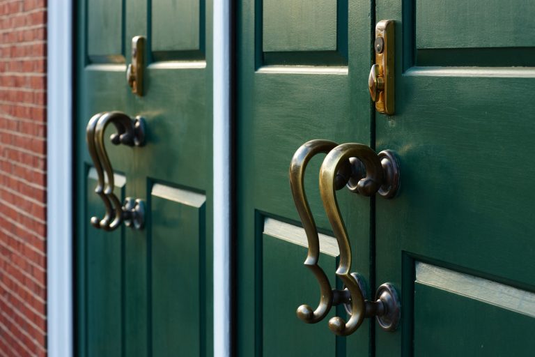 Bronze handles cast shadows on the green door, 11 Amazing Green Front Door Ideas