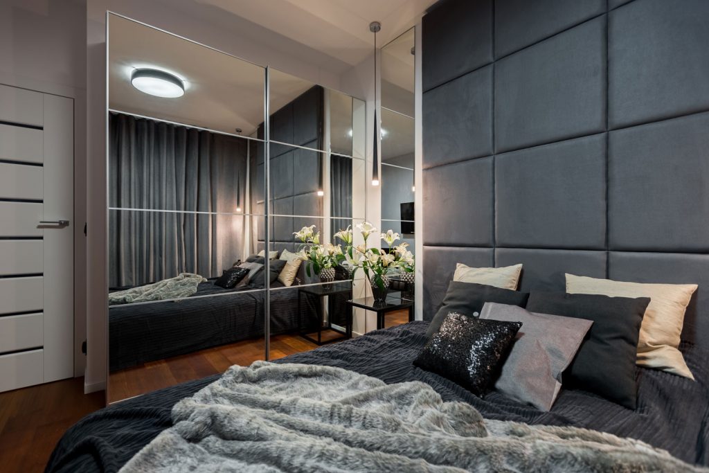Contemporary bedroom with double bed and mirrored wardrobe