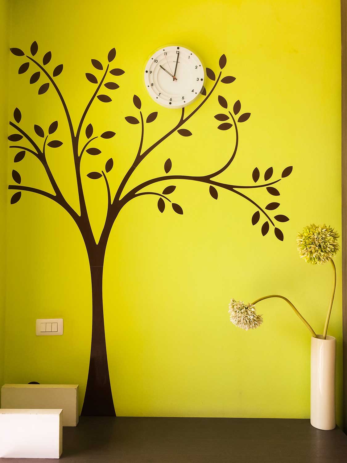 Green citron color wall with black tree wall decal and wall clock