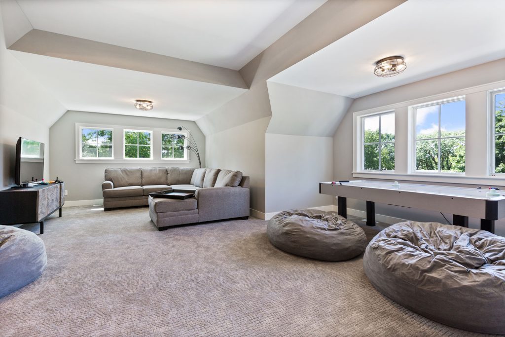 Living room with carpet flooring with poufs and gray sectional sofas