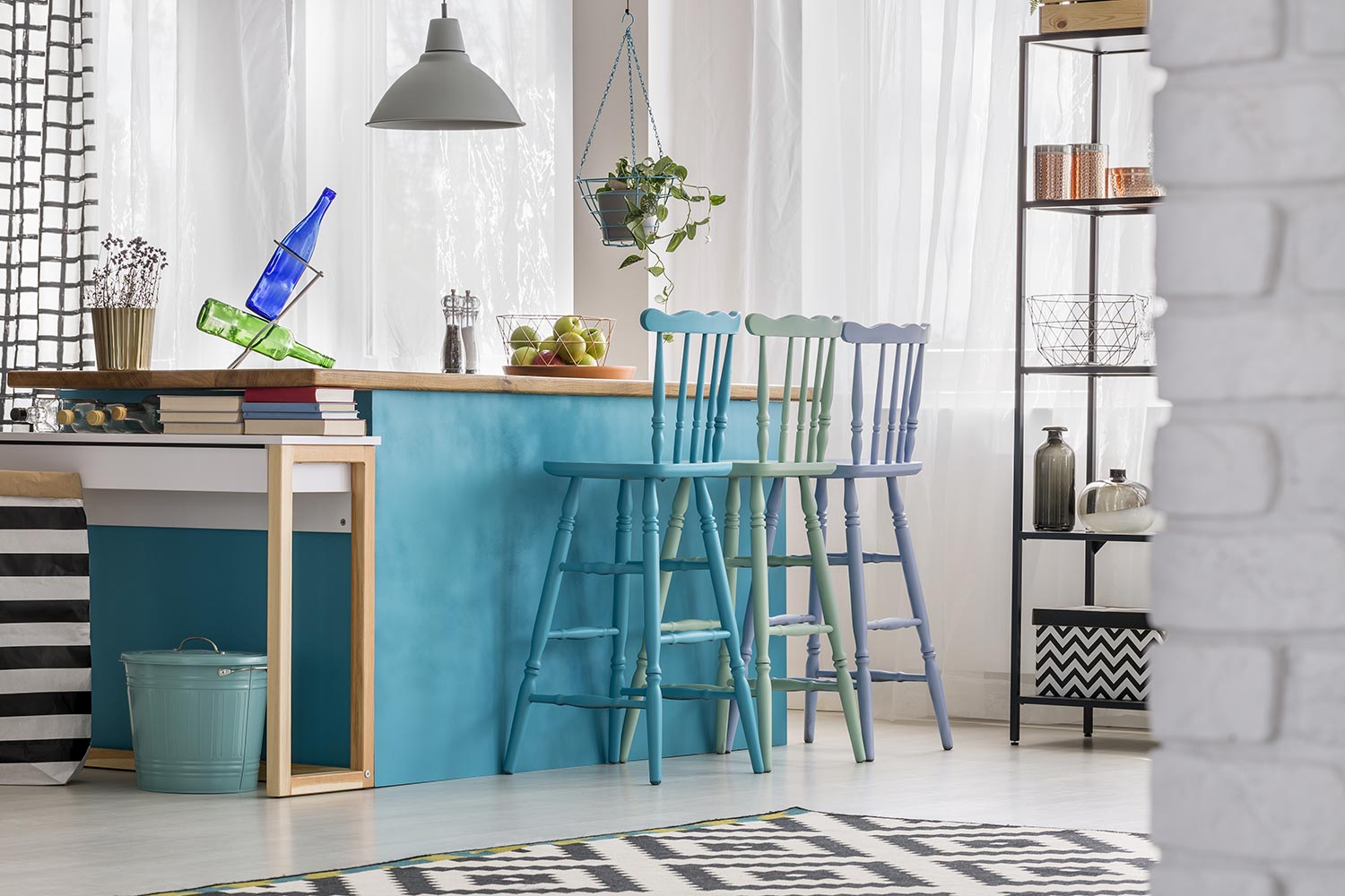 Pastel barstools in colorful kitchen interior with turquoise island