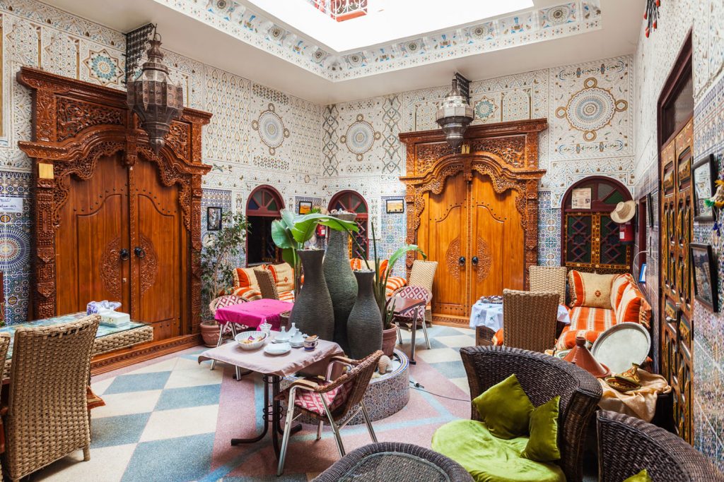 Traditional Moroccan living room or Riad consisting of an interior garden and ogee tile patterns on the wall