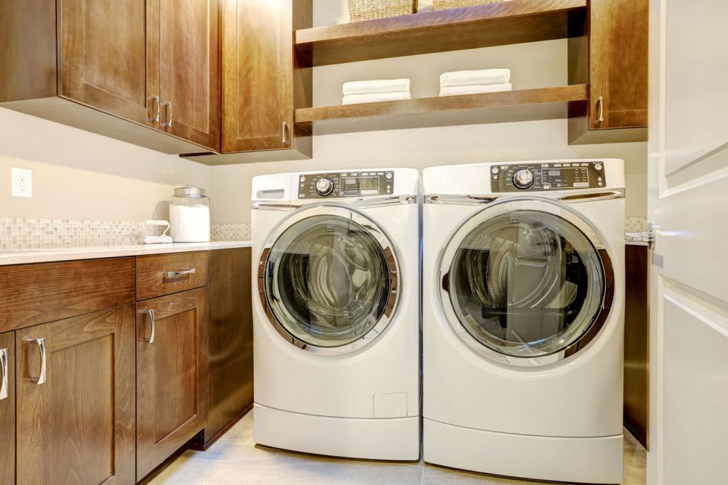 White washing machine and dryer inside rustic laundry room