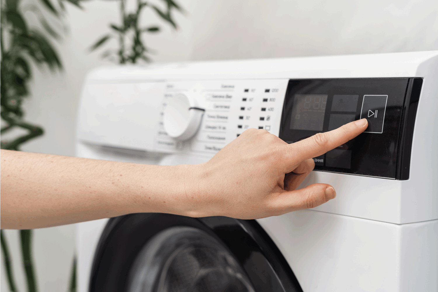 woman hand select settings for laundry on modern digital display. automatic washing machine with touch screen on control panel