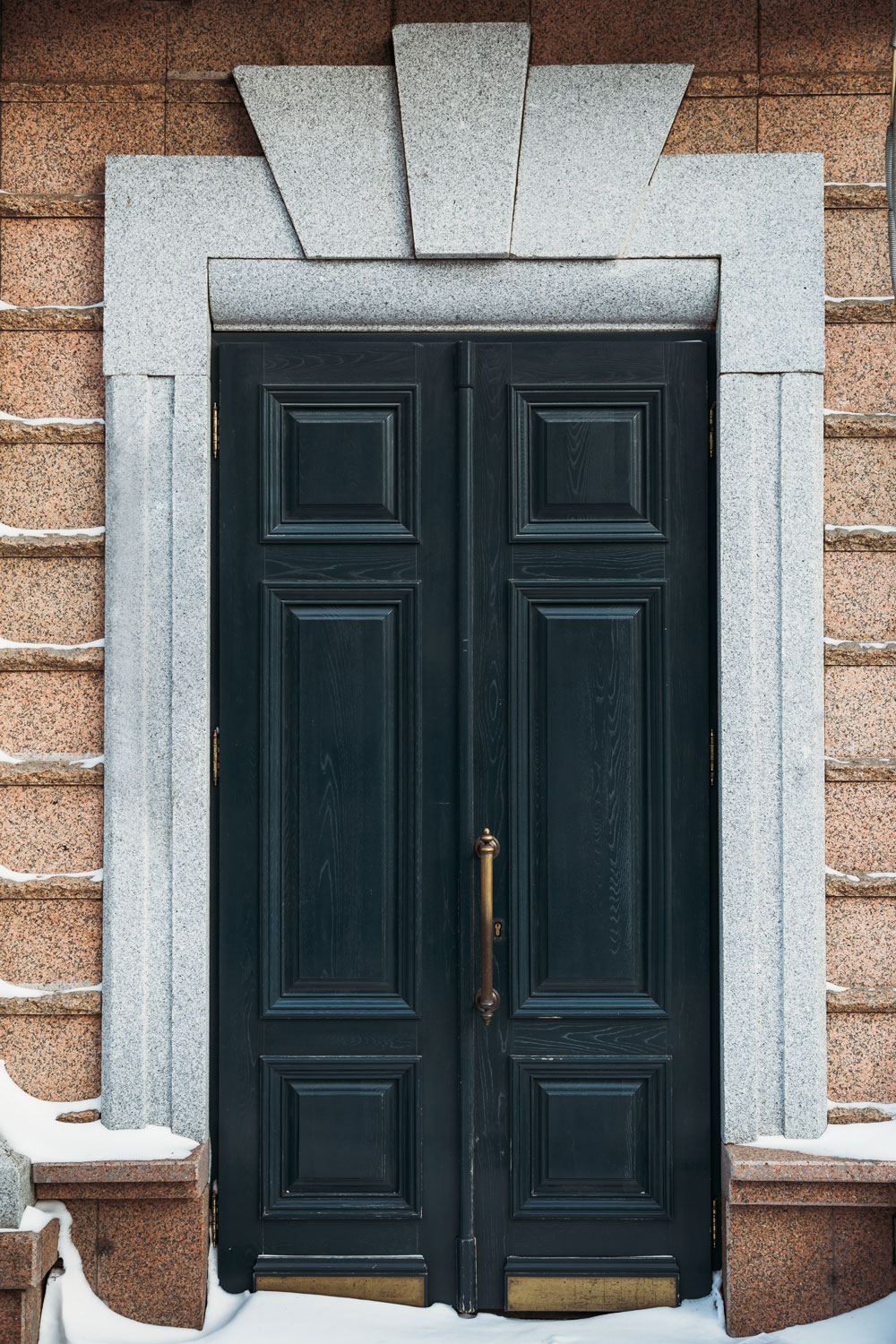 A black French door with a concrete trim