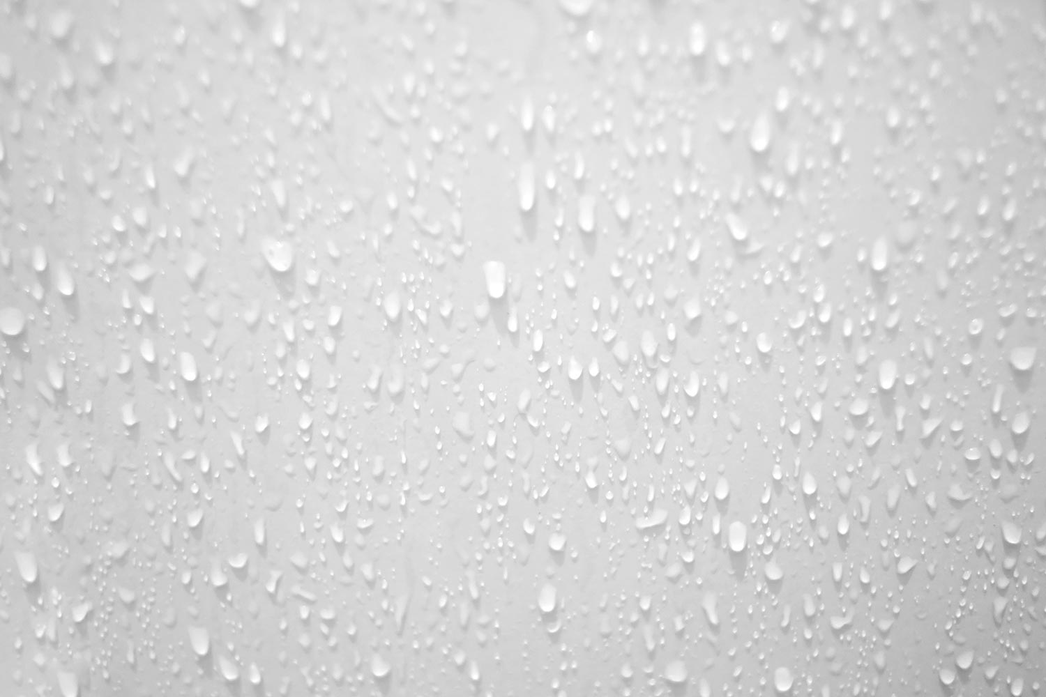 Blurred many water droplets on a white wall in a restroom area