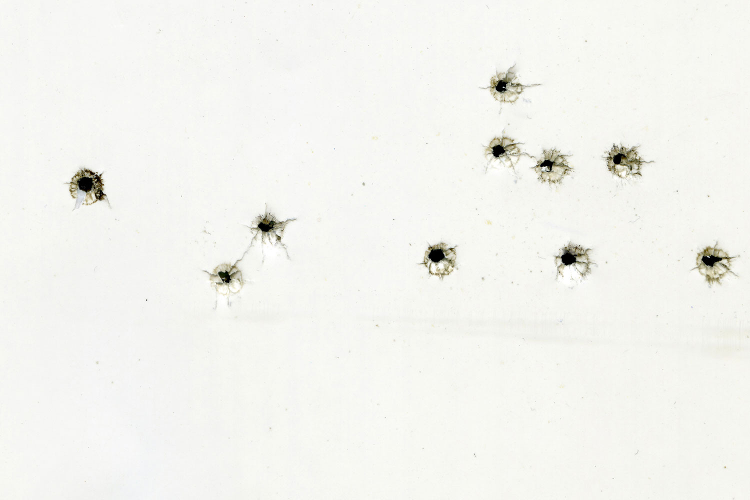 Bullet holes on a white sheet of paper, gunshot damage, abstract background.