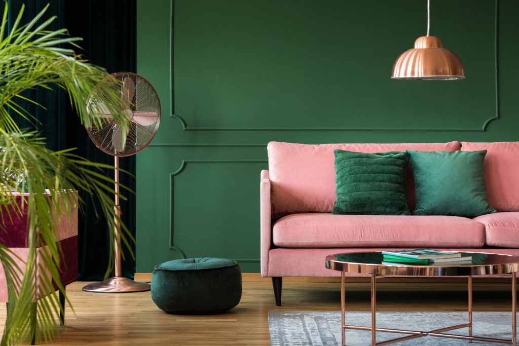 Copper lamp and table in a green living room interior.