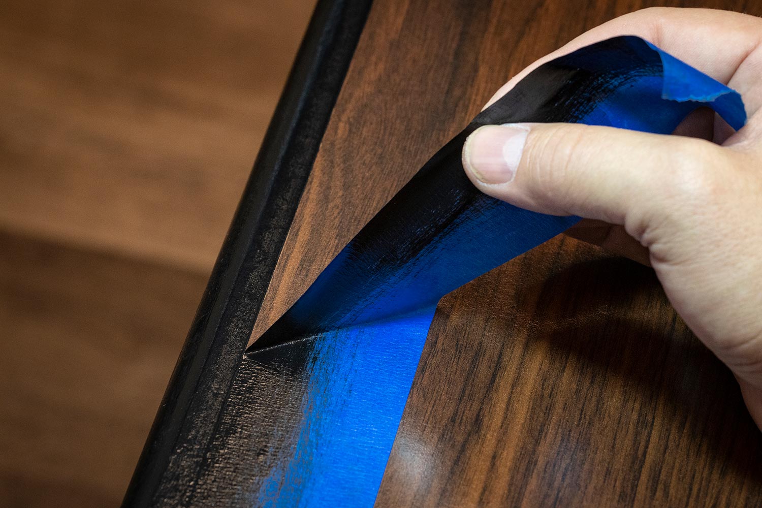 Hand removing blue painter's tape