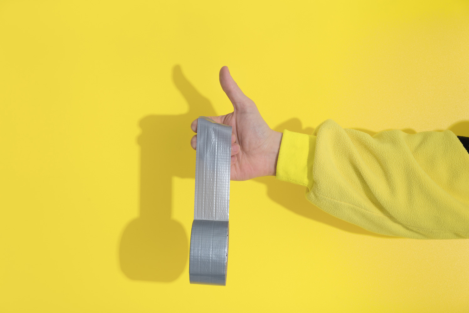 Male hand in yellow kugurumi holds Ultimate Gray tape sticks