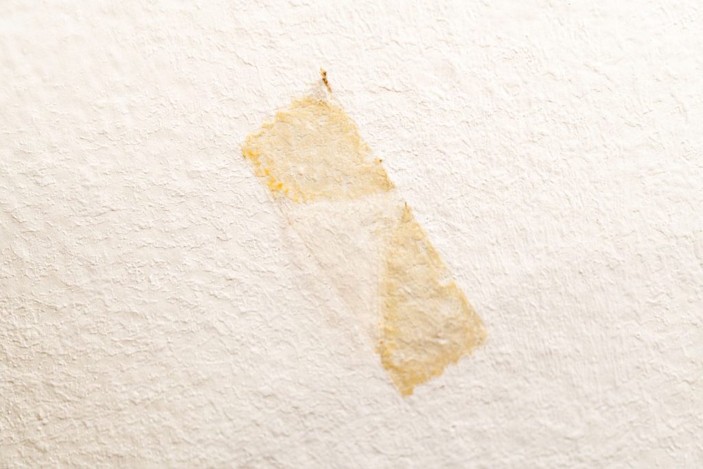 Mark of double-sided adhesive tape on the white wall.