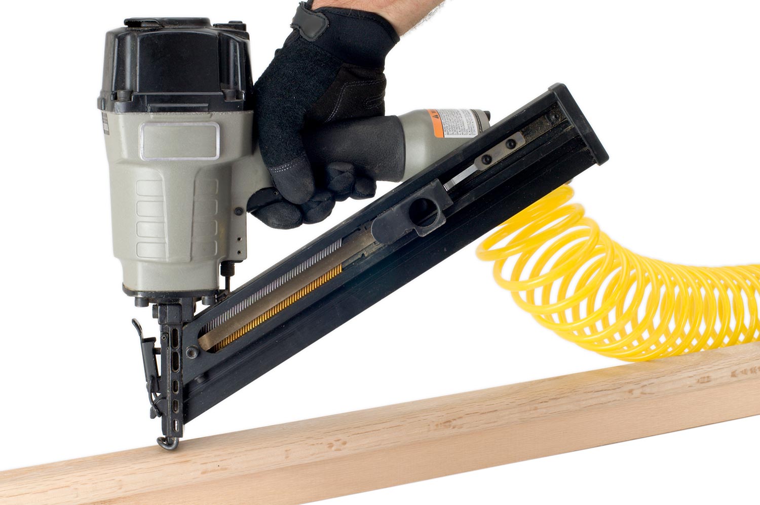 Pneumatic nail gun is being used to join tow pieces of oak trim