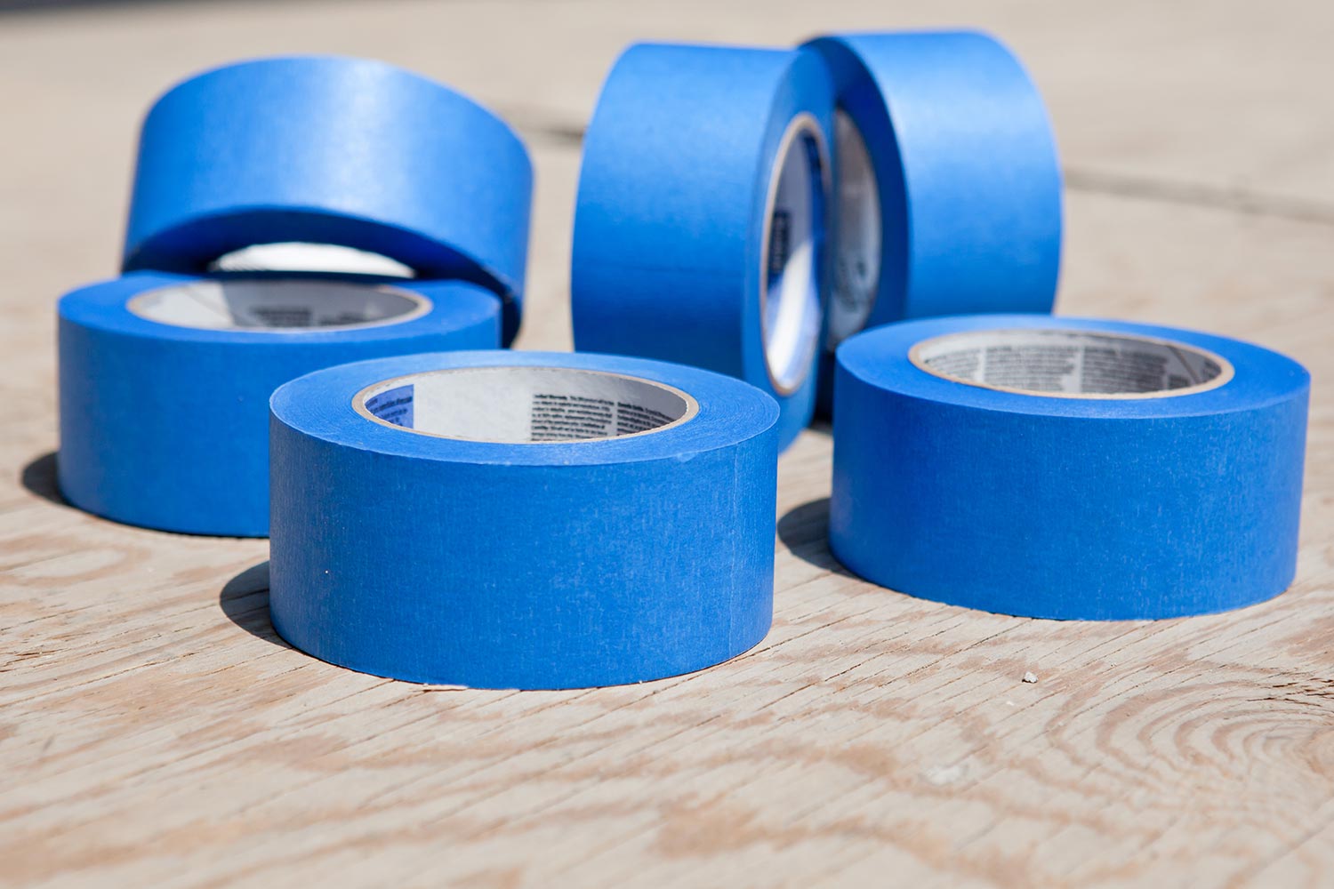 Roll of blue painters tapes over plywood
