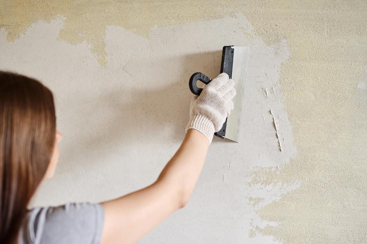 Woman plastering the walls with finishing putty in the room with putty knife, What's The Best Paint For Plastered Walls?