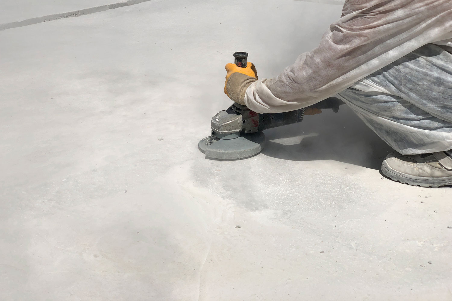 Worker sanding the concrete wall