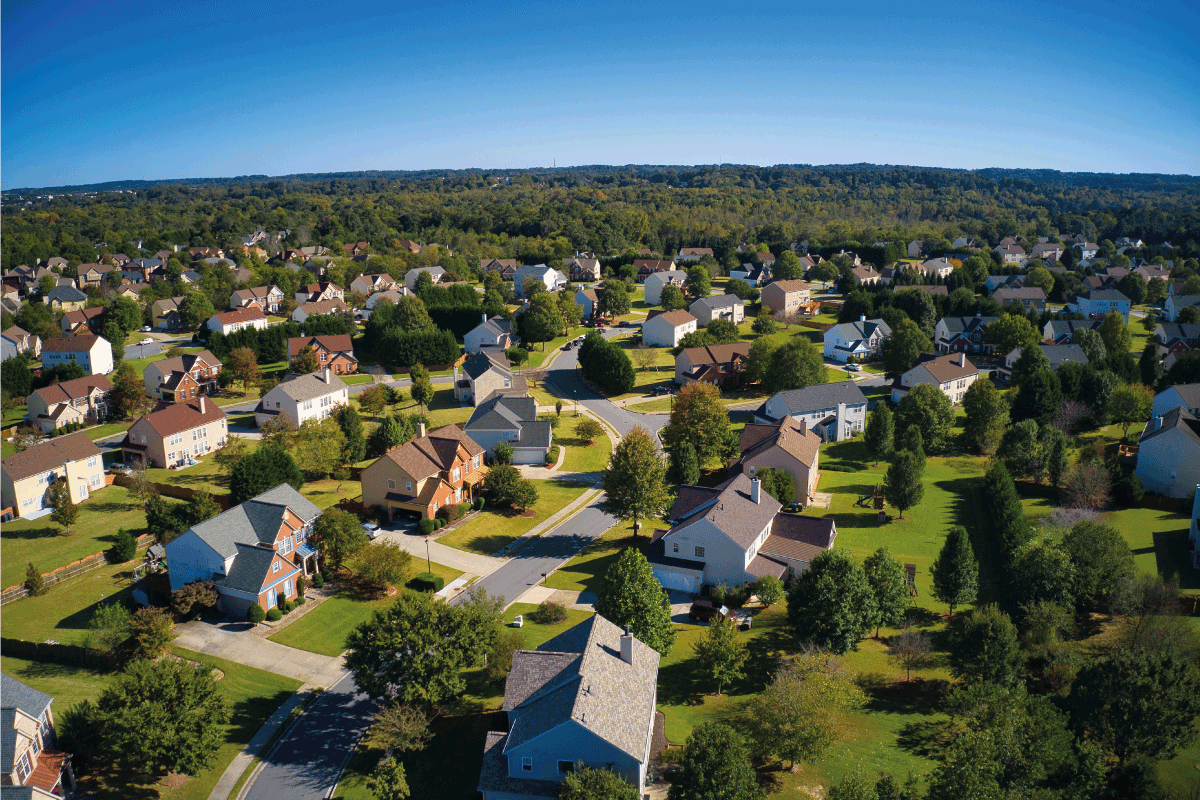 an upscale suburbs with gold course, lake, houses and roof tops. 8 Types Of Suburban Houses