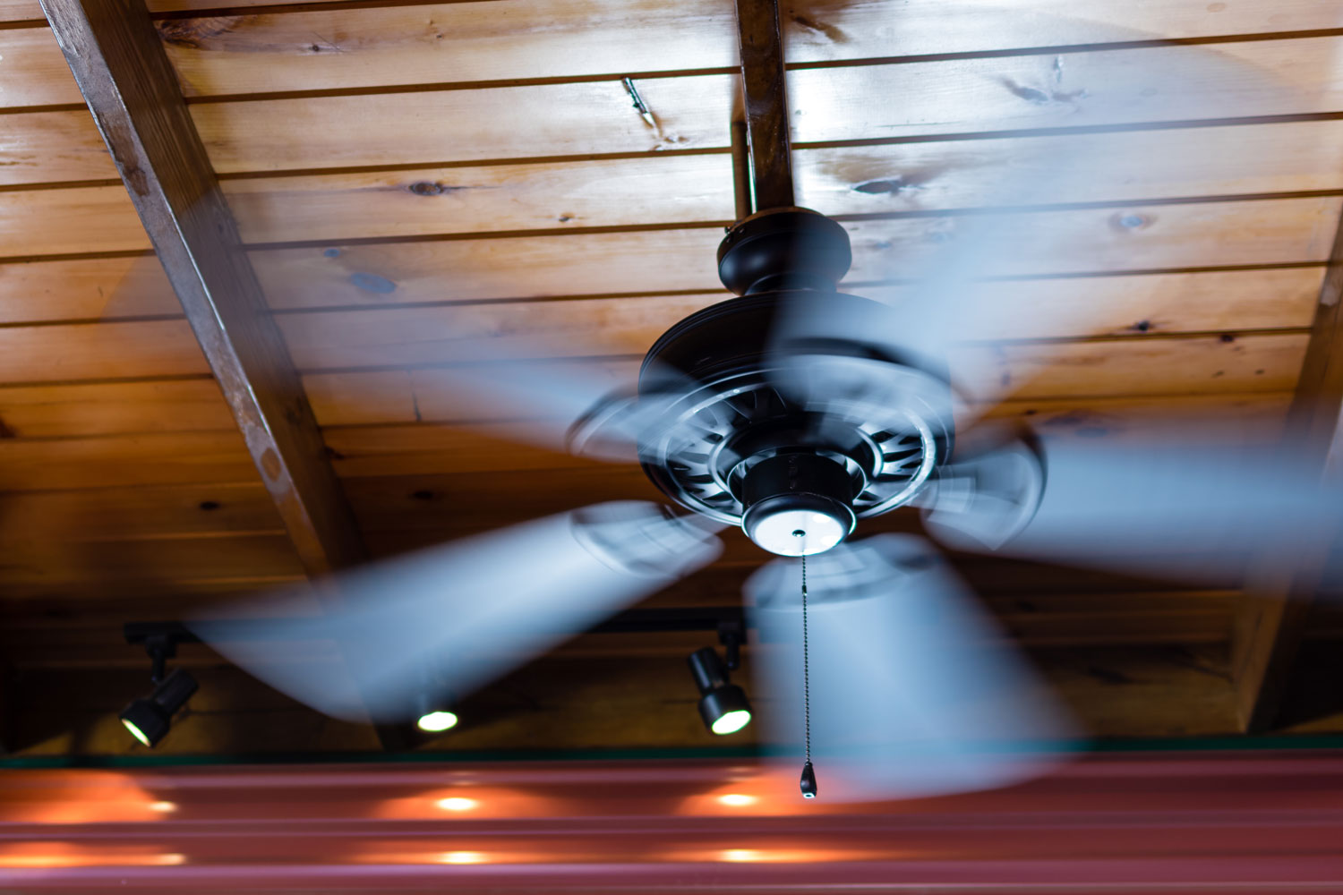 A ceiling fan inside a rustic designed room