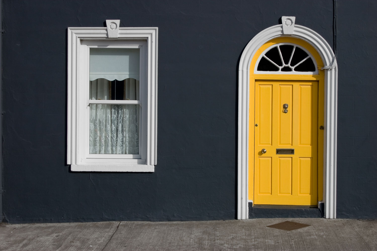 A purple and yellow colored front facade with yellow front door and white trim