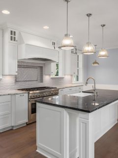 Beautiful kitchen in new luxury home with large island, hardwood floor, and pendant lights, How To Hide Kitchen Vent Pipe