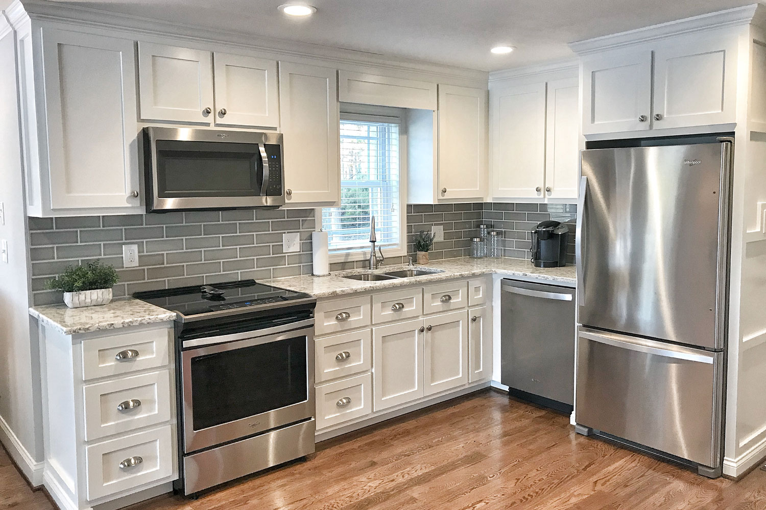 Classic and luxurious modern kitchen with white cabinets, silver cabinet handles and kitchen appliances
