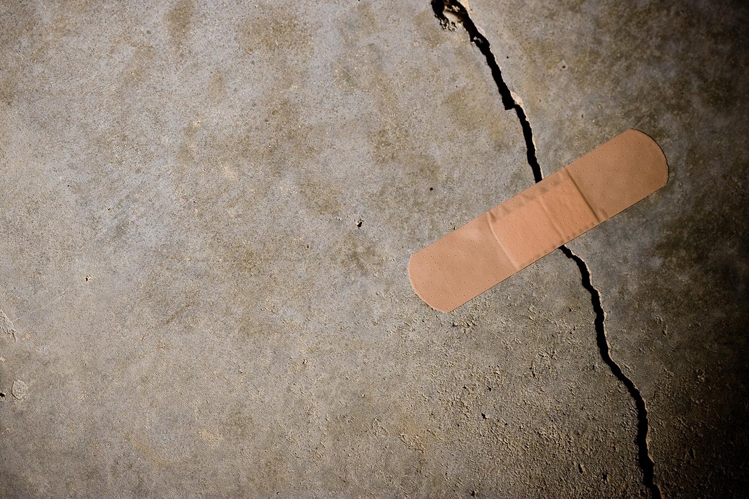Crack in concrete with band-aid on top