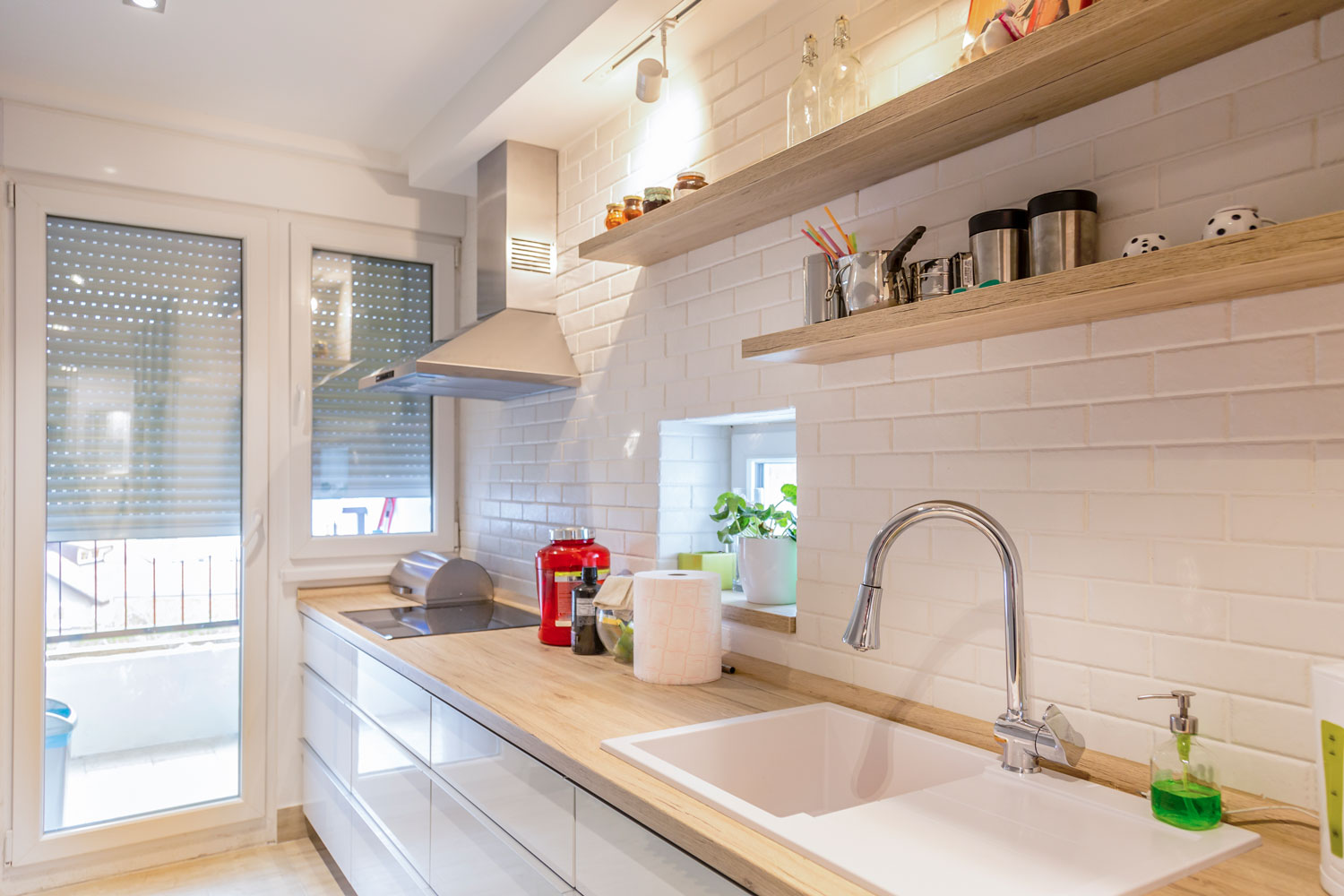 Minimalist designed kitchen with white brick backsplash and wooden countertop