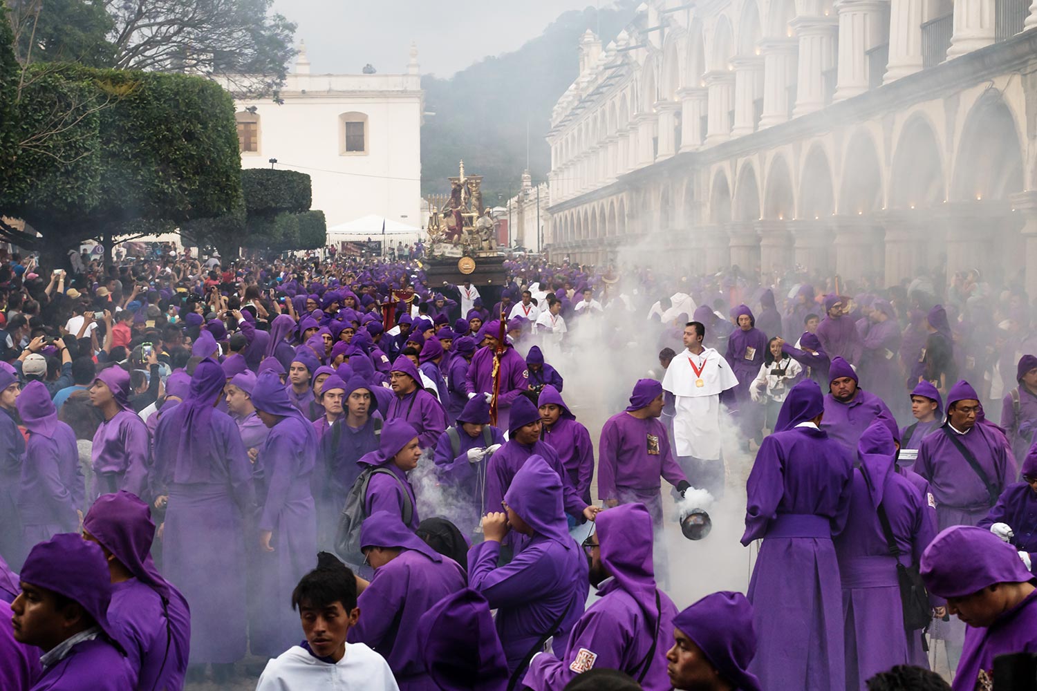 Priest in incense smoke in front of float at the procession San Bartolome de Becerra at the Plaza Mayor