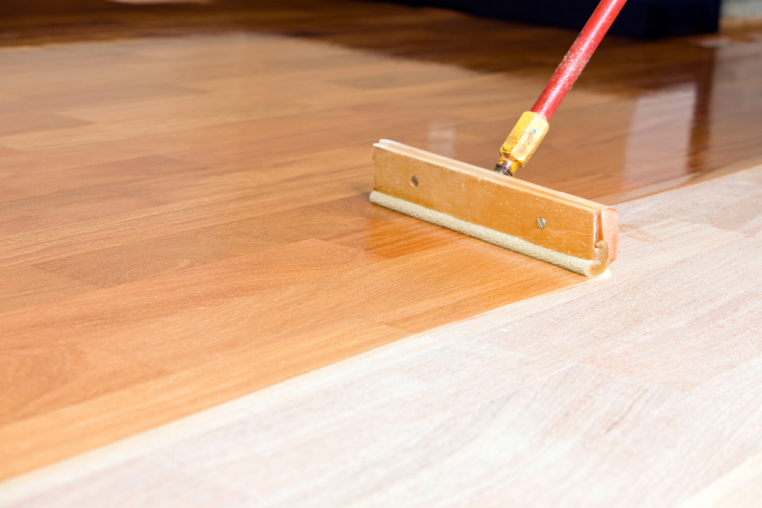Squeegee Style Brush Applying Clear Polyurethane to Hardwood Floor 
