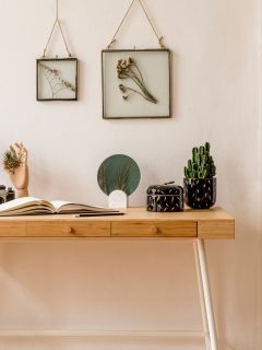 Stylish scandinavian interior of home office space with a lot of mock up photo frames. Modern neutral home staging.