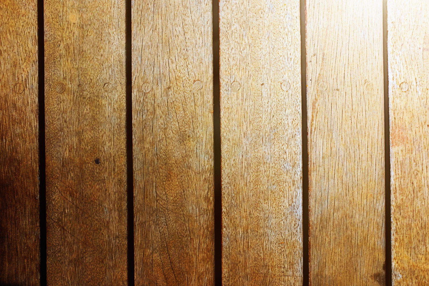 Textured wooden decking background with lighting going from light to dark.