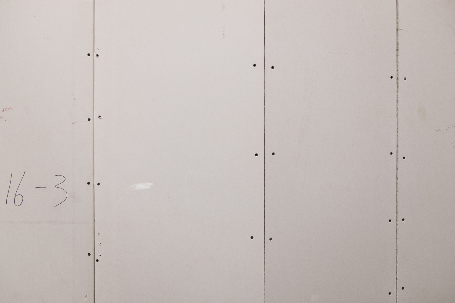 Unplastered drywall background with drywall screws.