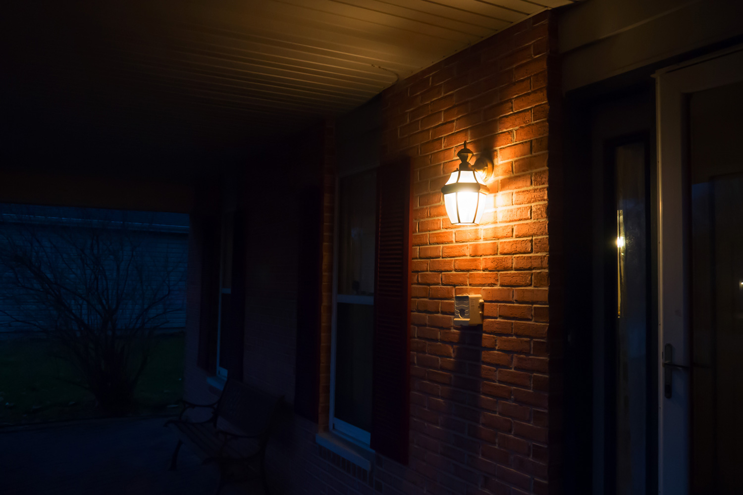 Warm light lantern illuminating the front porch at night