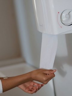A woman getting a paper towel, Where To Put A Paper Towel Holder In The Kitchen