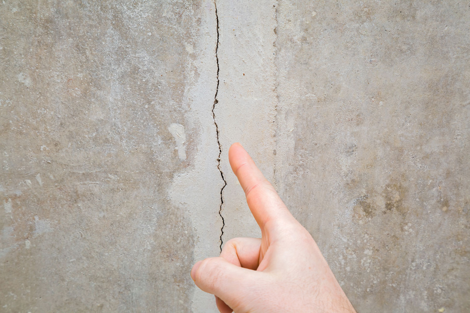 Worker pointing at the huge crack on the wall 
