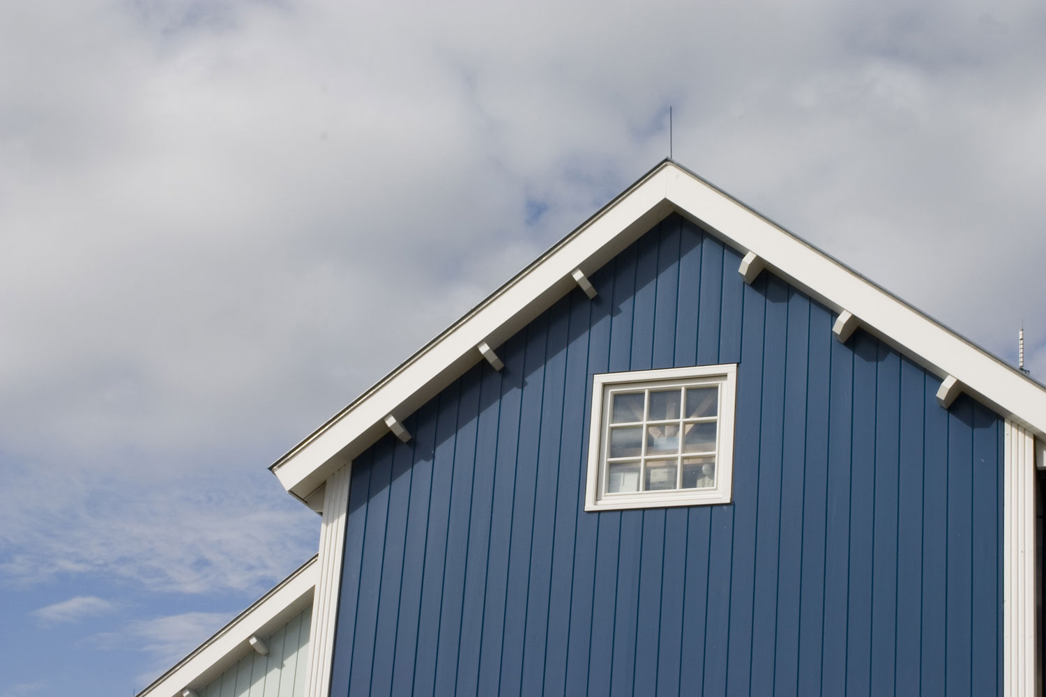 A blue siding farm house with white trims