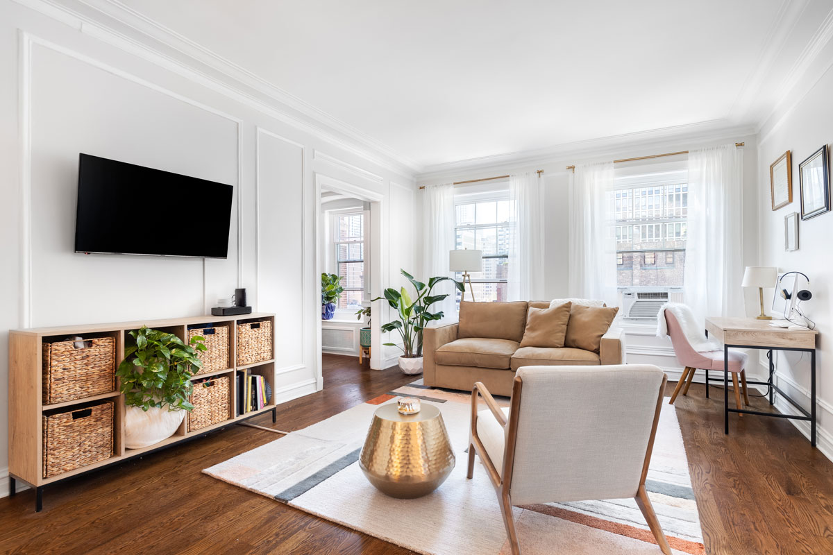 A bright, white living room in a downtown condo with cozy furniture
