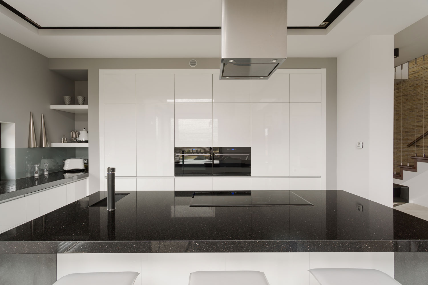 A huge black countertop inside an ultra modern kitchen