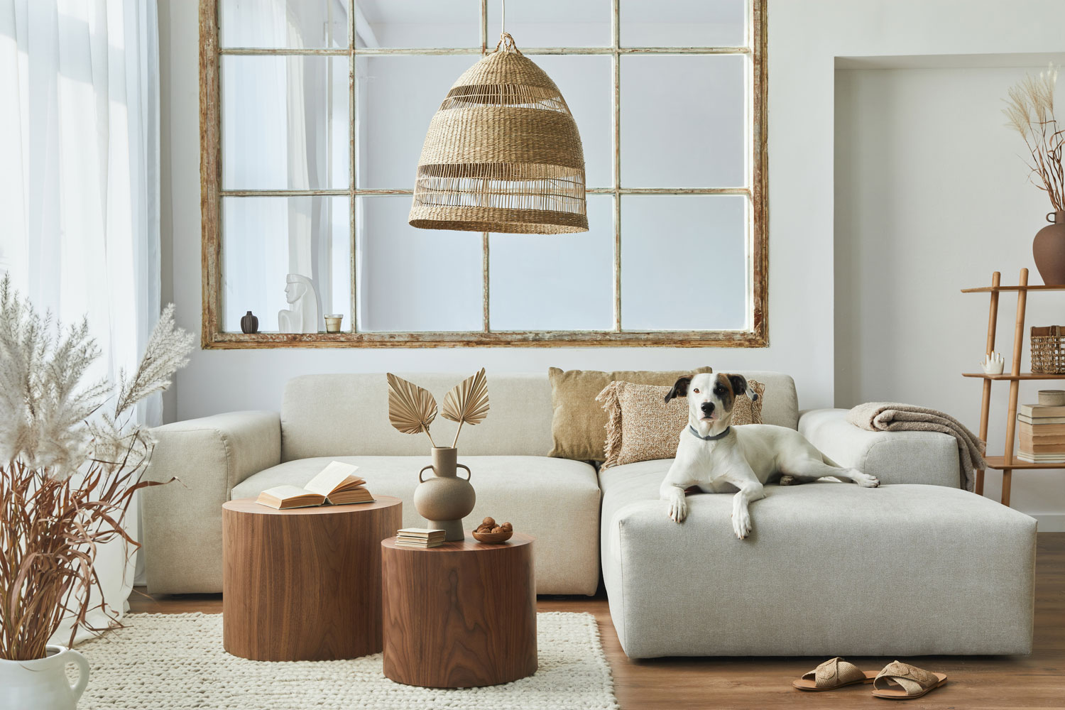 A light beige modular sofa with two round coffee tables inside bohemian inspired living room