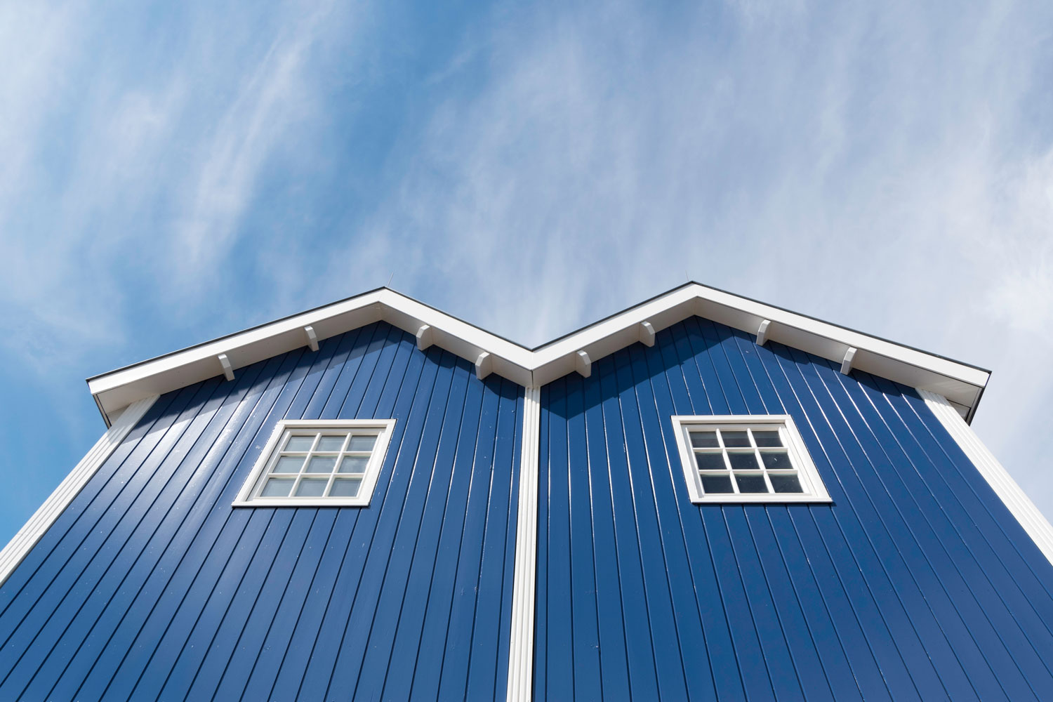 A tall blue walled farmhouse with white trims