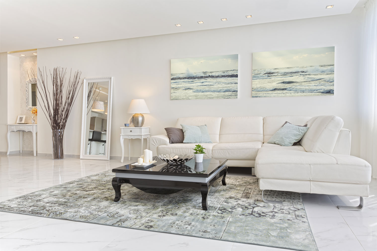 A white sectional sofa inside a modern white living room with gray abstract carpet
