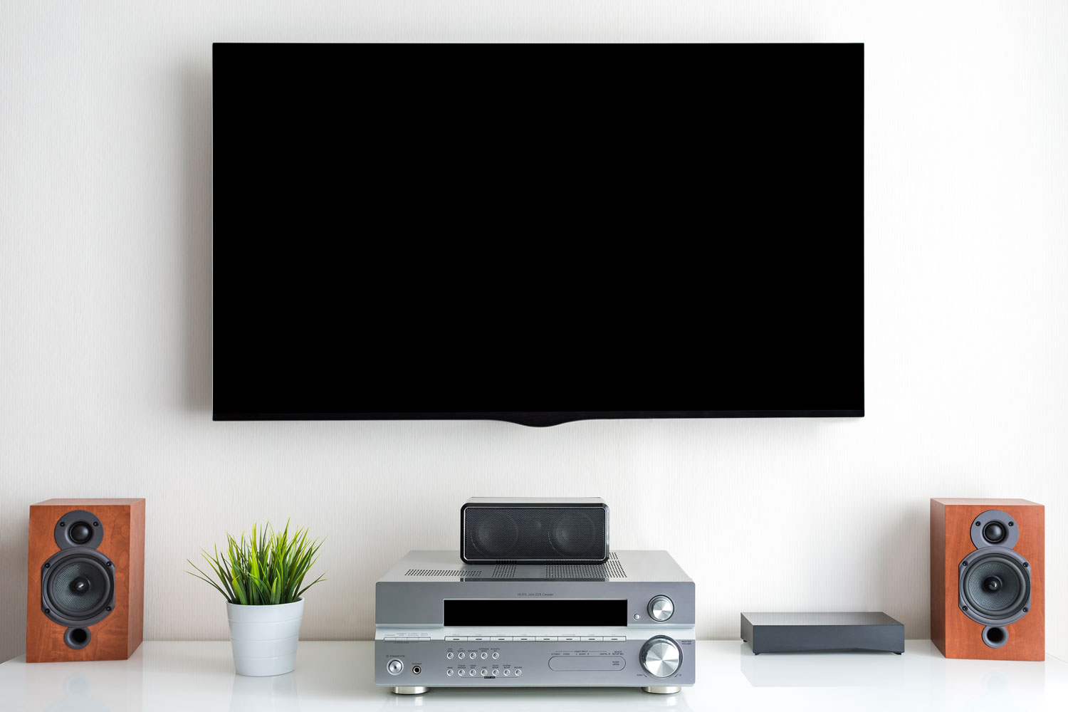 A wide screen TV with wooden speakers