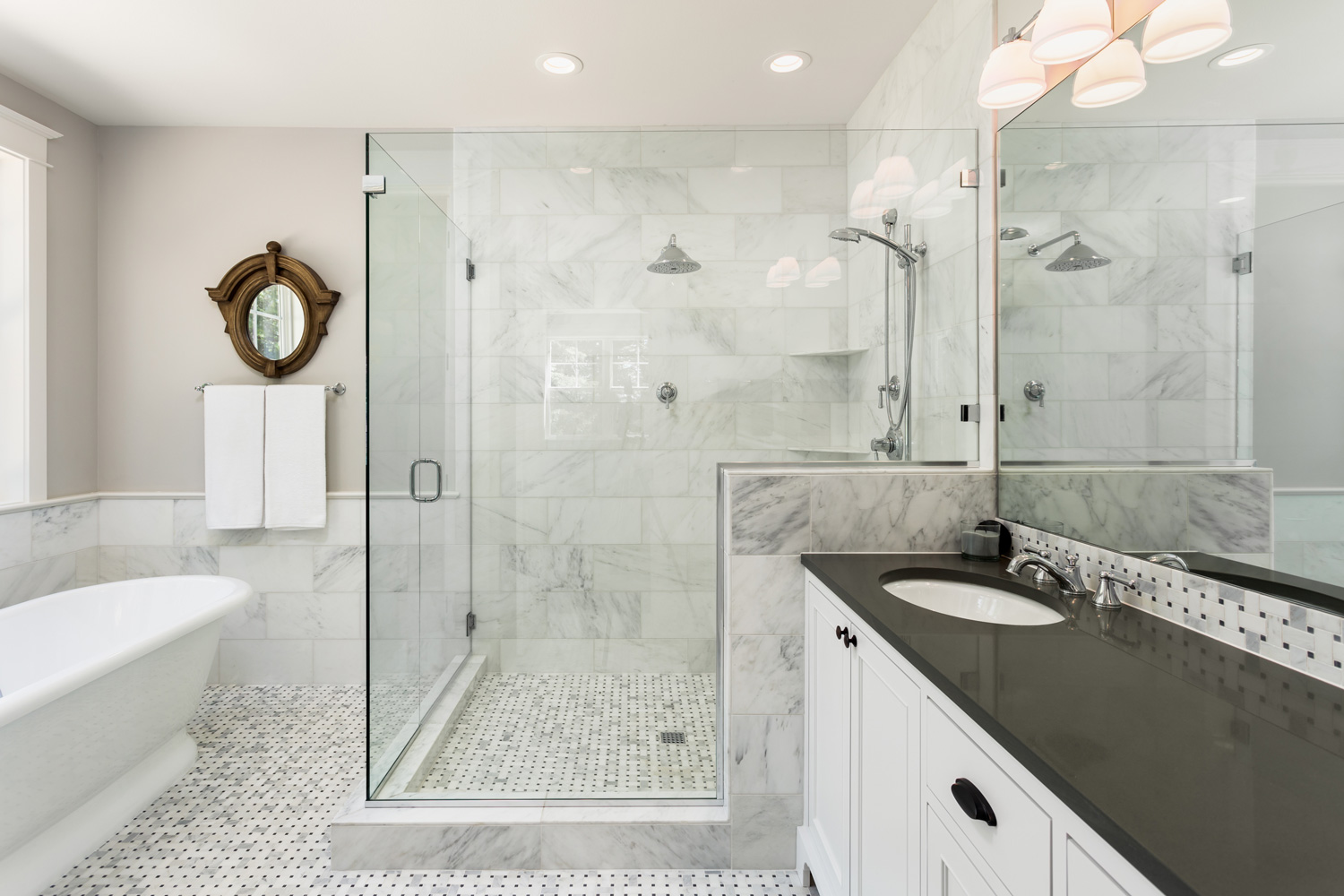 Beautiful master bathroom with shower, bathtub, and sink, with high end furnishings, lights on