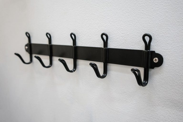 A black metal wall hanger mounted against white wall, Where To Hang Bath Mat To Dry