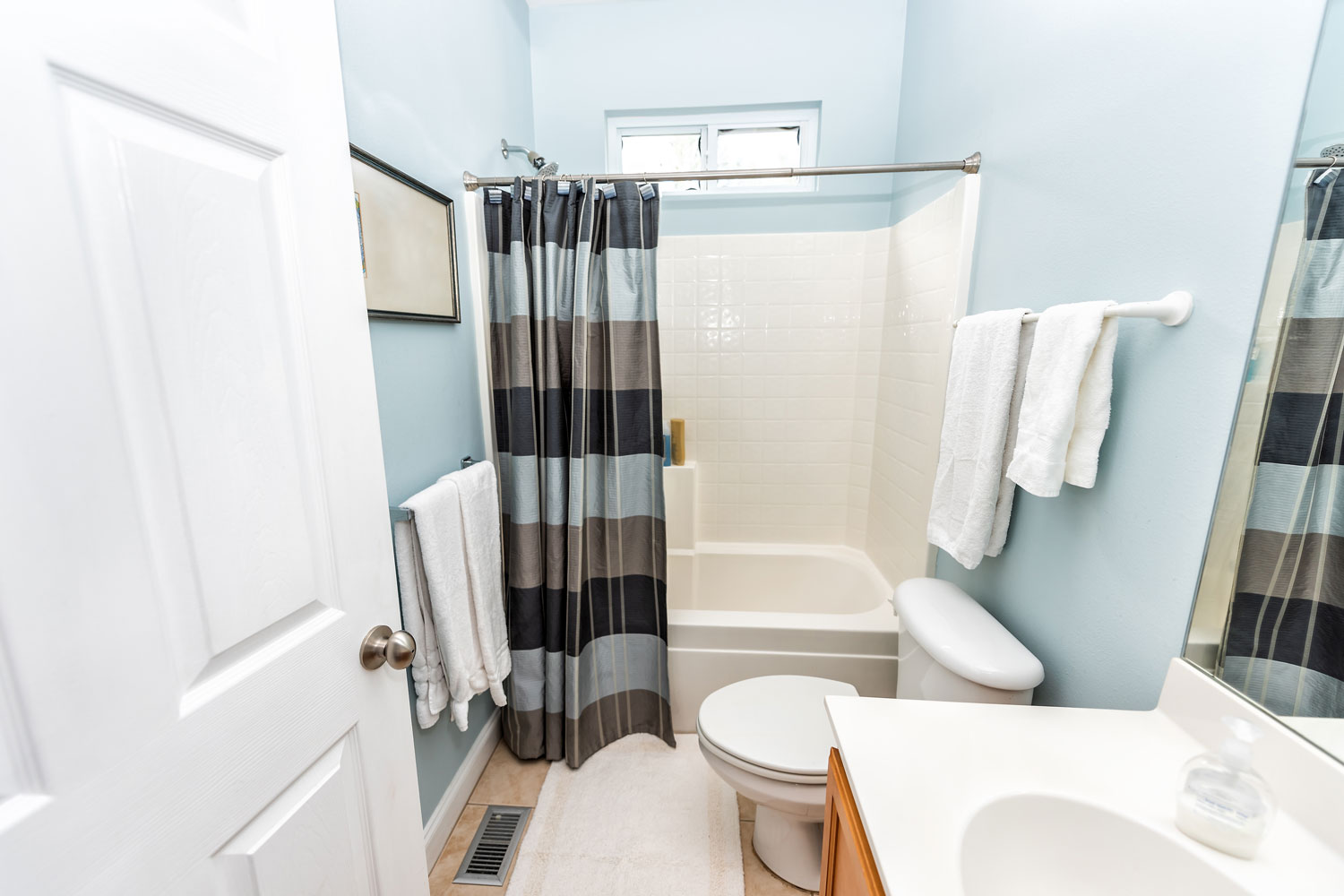 Blue painted bathroom walls with a shower curtain on the bathtub