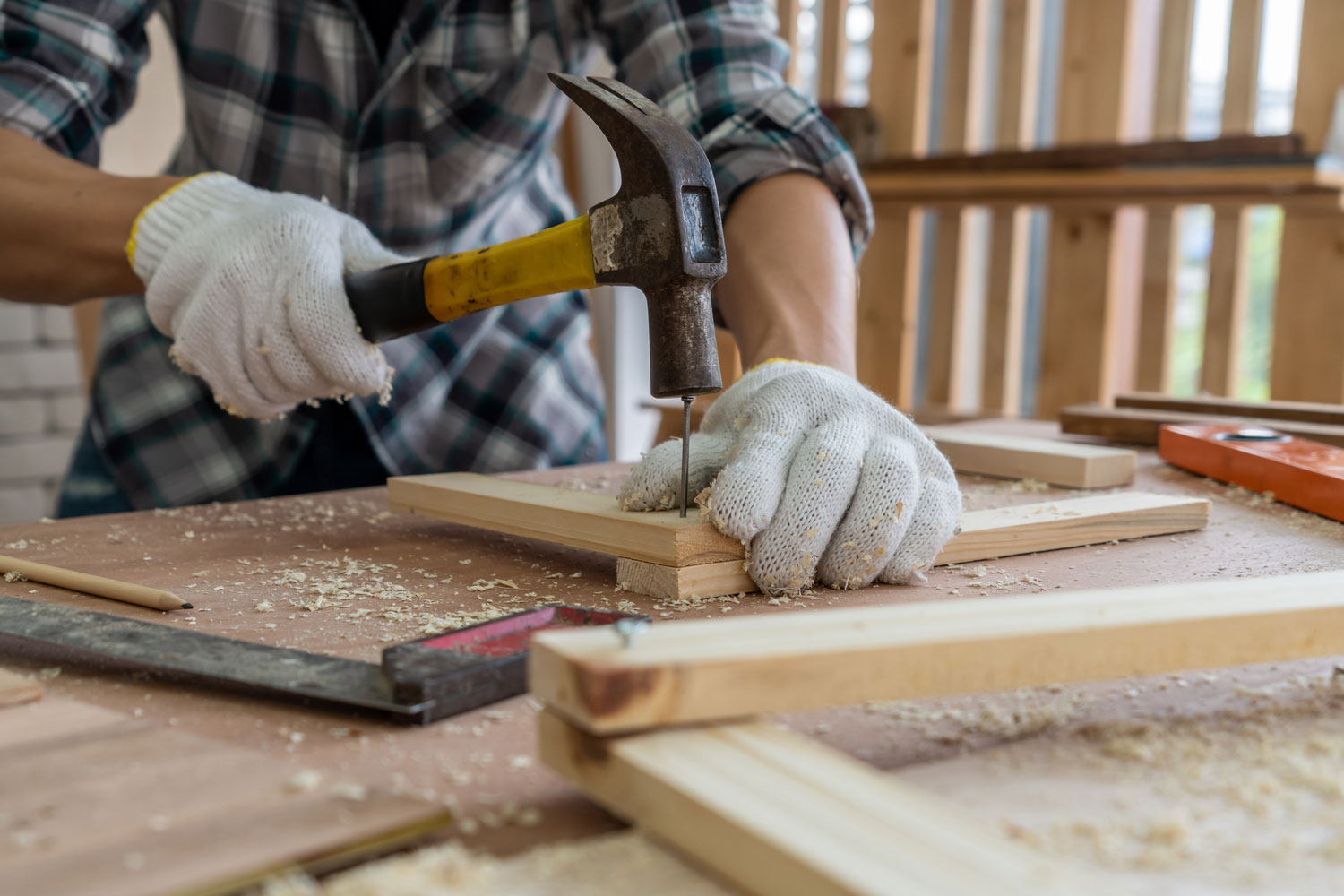 Carpenter making a frame using a hammer and nail