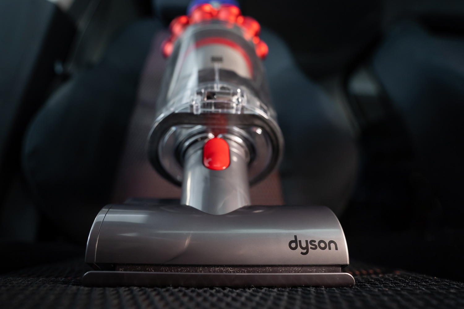 Close up of the Mini motorhead of Dyson Cyclone V10 Fluffy vacuum cleaner on car seats with car interior background.