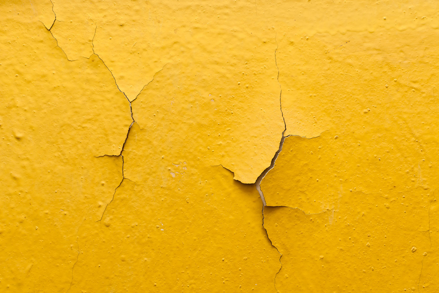 Cracked paint on a yellow wall