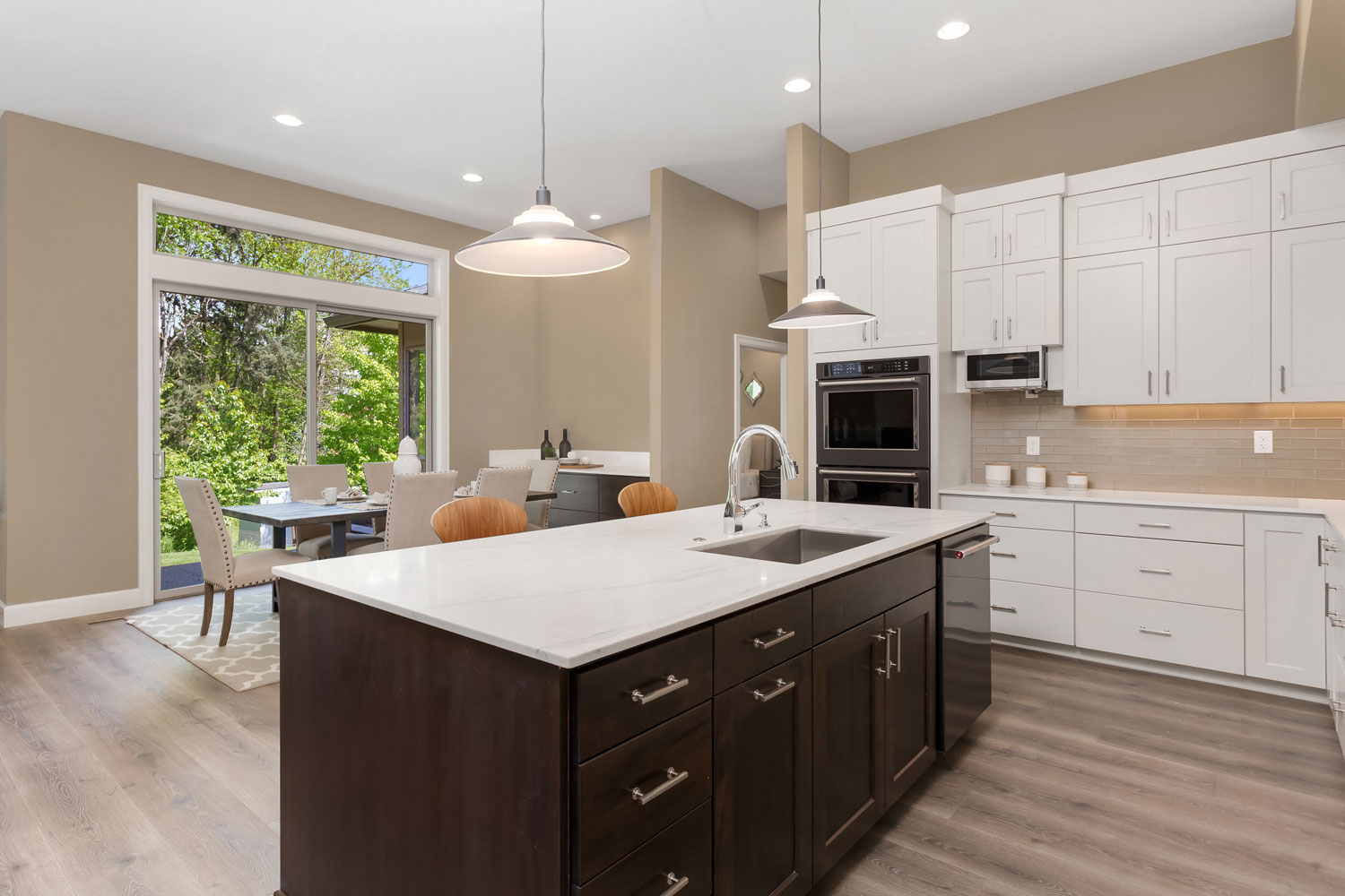 Dark oak kitchen cabinets matched with white countertops and dangling lamps
