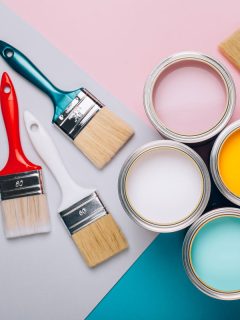 Four open cans of paint with brushes on bright background, Can Sherwin Williams Color Match Benjamin Moore?